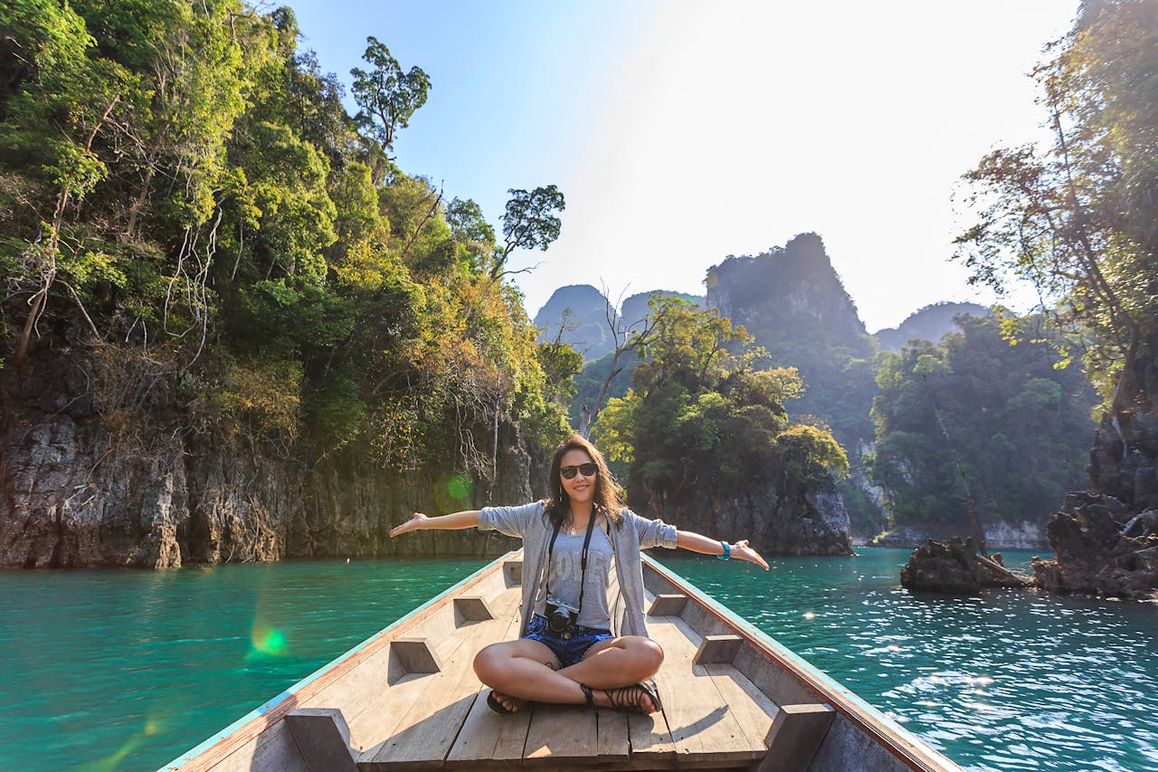 woman sitting in a boat with arms outstretched
