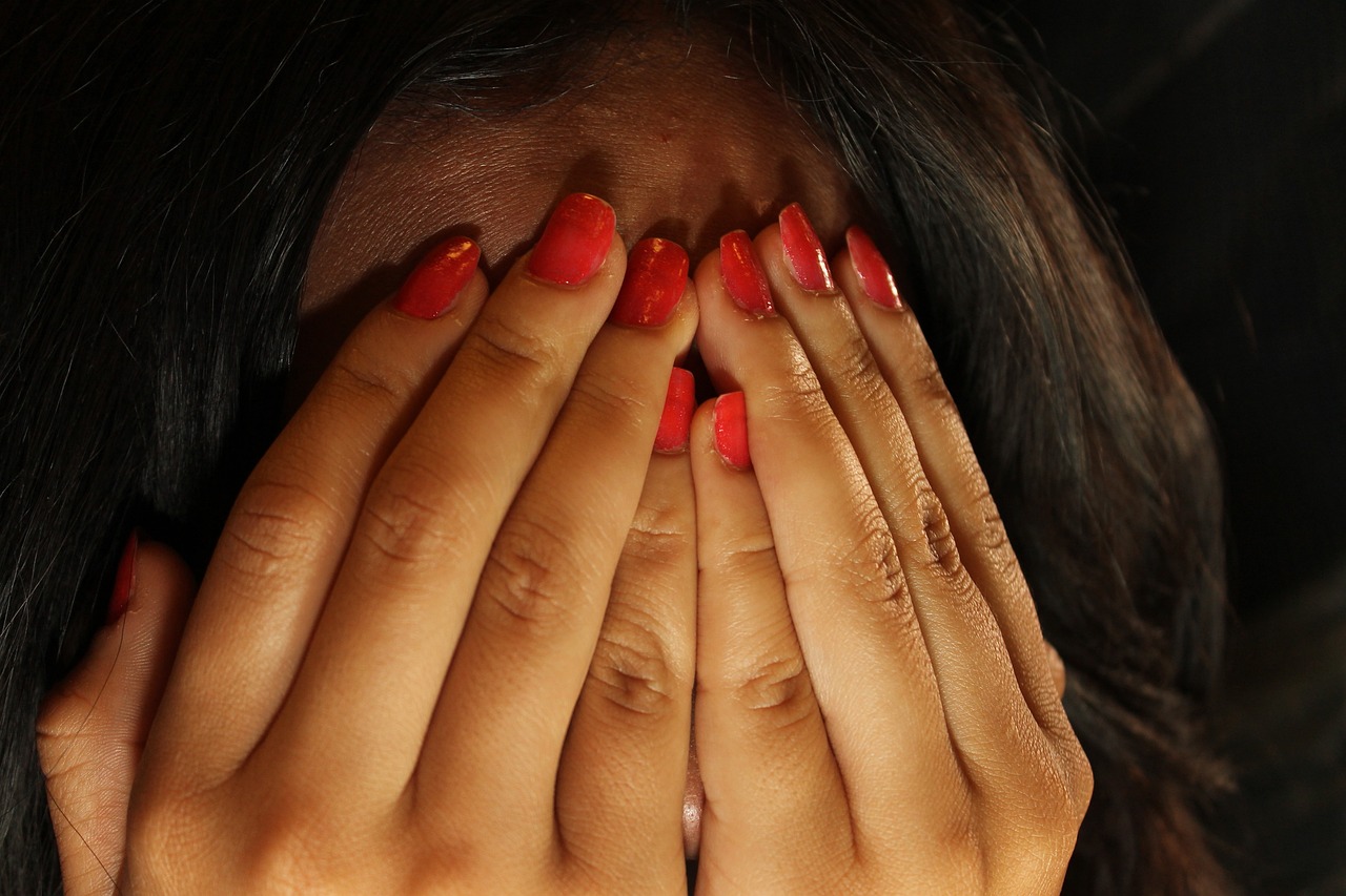 woman covering her face with her hands
